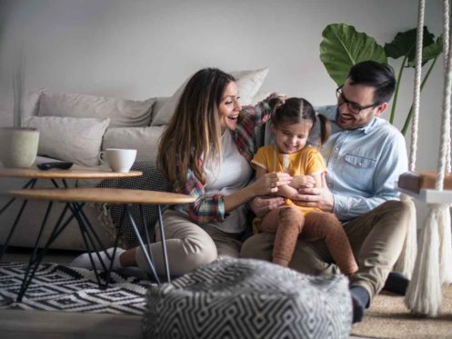 Parents playing with daughter at home.