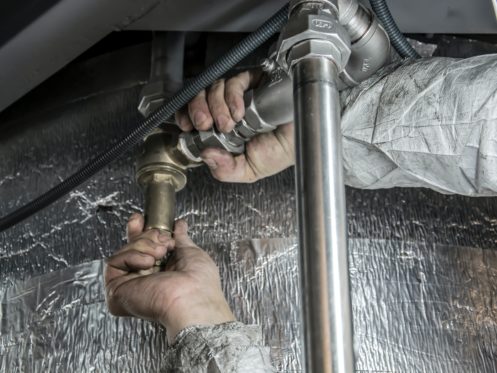 plumber checking pipes under the sink