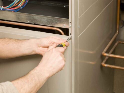 Repair Technician Removing Furnace Service Panel