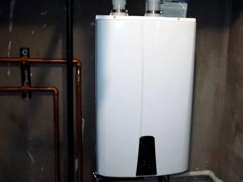 Tankless hot water heater installed in a basement utility room to save money and energy.